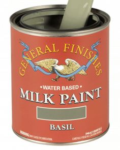 a can of water based milk paint with a spoon in it