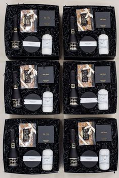 four black boxes with white and gold items in them, one is opened to show the contents