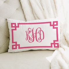 a pink and white pillow with the word monogrammed in cursive font