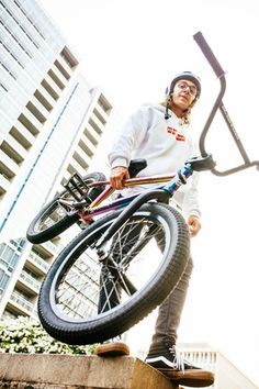 a man holding onto his bike while standing on some steps