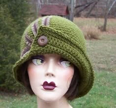 a mannequin head wearing a green knitted hat with buttons on the brim