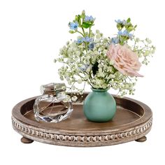 a blue vase with flowers on a tray