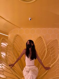 a woman standing in front of a butterfly sculpture