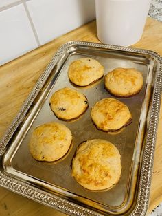 muffins on a tray next to a glass of milk