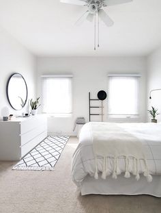 a bedroom with white walls and carpeted flooring