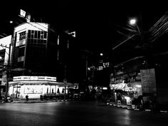 a black and white photo of a city street at night