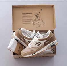 a pair of new balance shoes in a box with the map of england behind them