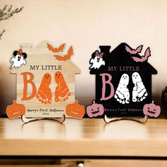 three wooden halloween signs sitting on top of a table