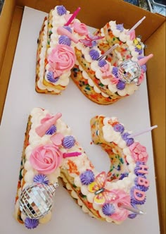 two birthday cakes in the shape of the number 50 are decorated with flowers and candles