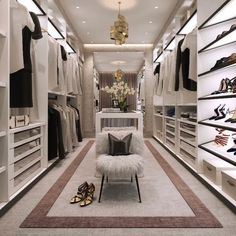 a walk in closet filled with lots of white shelves and shoes on top of them