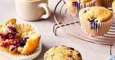 blueberry muffins on a wire rack next to a cup of coffee