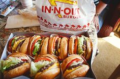 several hamburgers and fries are sitting on the counter