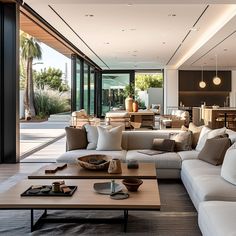 a living room filled with lots of furniture and large glass doors leading to an outside patio