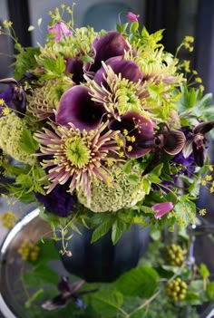 a vase filled with purple and green flowers