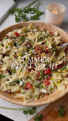 a wooden bowl filled with pasta and vegetables