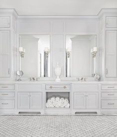 a white bathroom with double sinks and mirrors