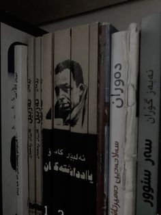 a book shelf with several books on it and an image of a man's face