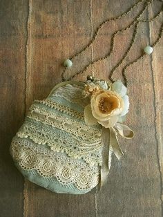 an old purse with a flower on it is laying on a table next to some beads