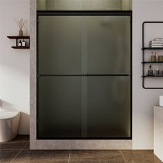 a bathroom with a glass shower door next to a toilet