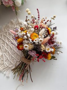 a bouquet of wildflowers and other flowers on a white surface