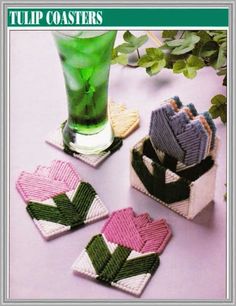 four knitted coasters sitting on top of a table next to a green drink