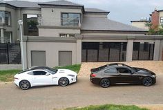 two black and white sports cars parked in front of a house