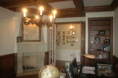 a living room filled with furniture and a fire place in front of a mantle covered in pictures