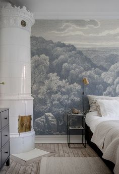 a bed room with a neatly made bed and a painting on the wall