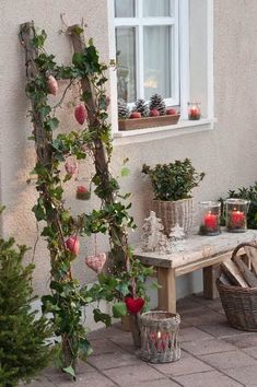 a wooden bench sitting in front of a window next to potted plants and candles