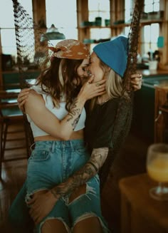 two women sitting on a swing kissing each other