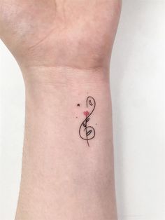 a music note tattoo on the wrist with a rose and treble in black ink