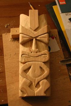 a carved wooden object sitting on top of a table next to a pair of scissors