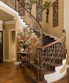 an elegant staircase with wrought iron railing and wood flooring