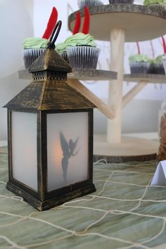 cupcakes are sitting on the table next to a lantern