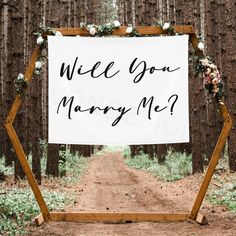 a sign that says, will you marry me? in front of a dirt road