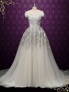 a wedding dress on display in front of a purple background