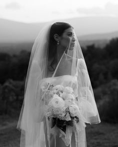 a woman wearing a veil and holding a bouquet