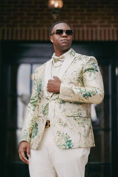 a man in a white suit and sunglasses