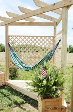 a wooden pergolan with a blue and white hammock hanging from it