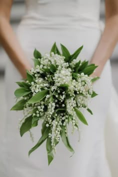 a bride holding a bouquet of white flowers