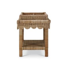 a wicker side table with scalloped edges and a shelf on the top