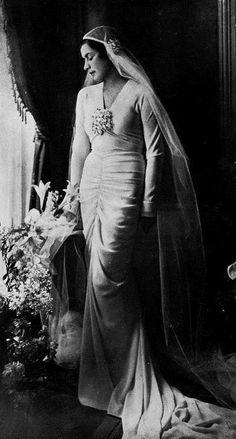 an old black and white photo of a woman in a wedding dress