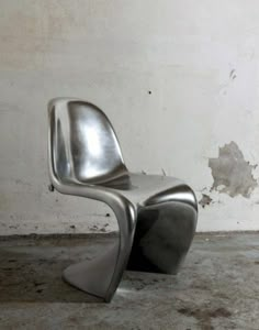 a modern chair sitting in front of a white wall