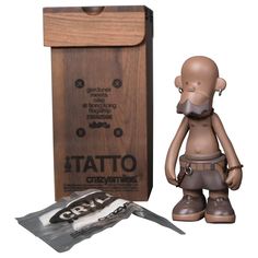 a small figurine next to a wooden box with a chocolate bar in it