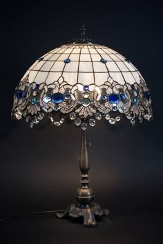 a lamp that is sitting on top of a table with a blue glass shade over it