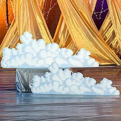 an artistic scene with clouds and curtains in the background