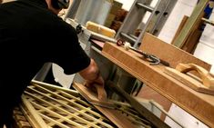 a man working on some wood in a shop