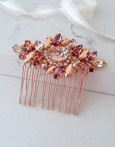 a close up of a hair comb with pink stones on the front and back of it