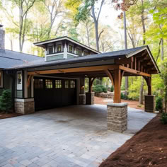 a house with a covered driveway in front of it and lots of trees behind it