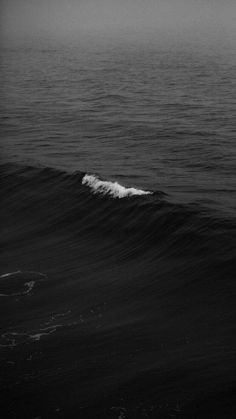 a person riding a surfboard on top of a wave in the middle of the ocean